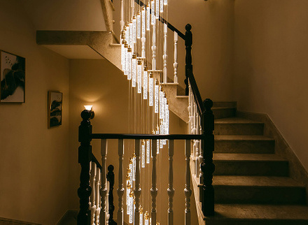 Warm lighting illuminating a spiral staircase from the side